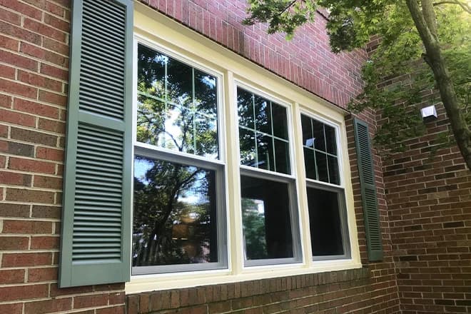 Closeup of new white wood windows in a brick house 1